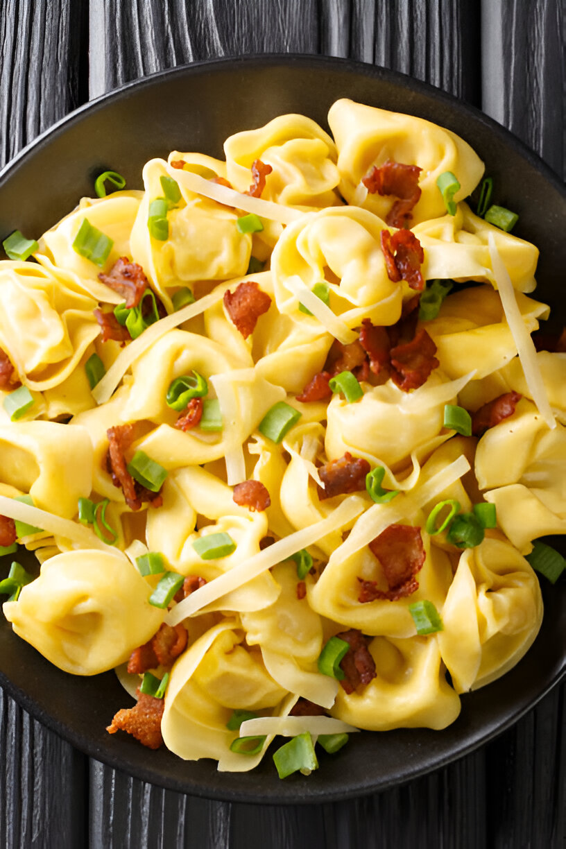 A close-up of a bowl of pasta filled with bacon and green onions