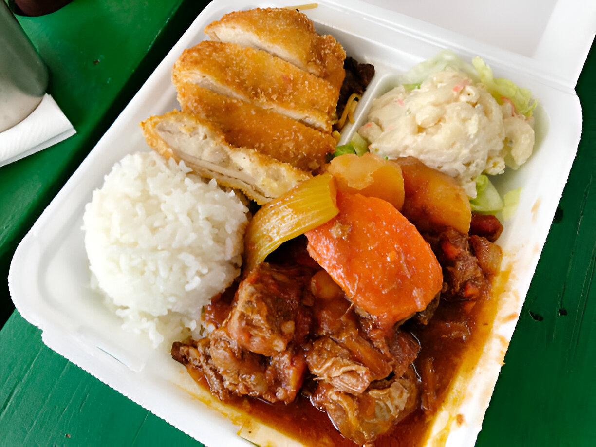 A meal consisting of fried chicken, rice, stewed vegetables, and a side salad served in a takeout box.