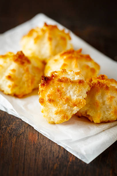 A plate of golden brown coconut macaroons resting on parchment paper.