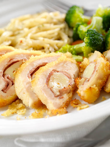 Plate of chicken cutlets stuffed with meat and cheese, served with pasta and broccoli