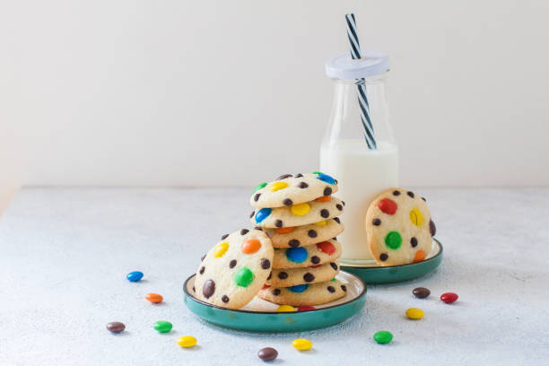 Colorful cookies with chocolate chips and a glass of milk