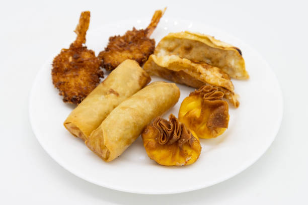 A plate of assorted fried snacks including spring rolls, shrimp, and pastries.