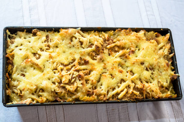 A rectangular dish of baked pasta topped with melted cheese and golden-brown crust.