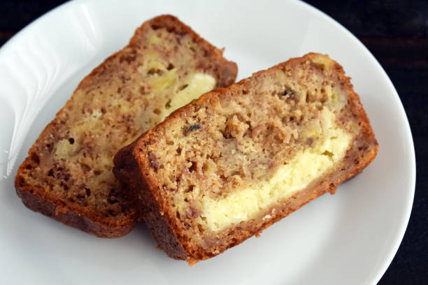 Two slices of banana bread with a cream cheese filling on a white plate.