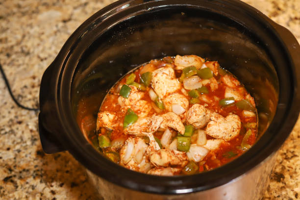 A close-up view of a slow cooker filled with a chicken and vegetable dish.