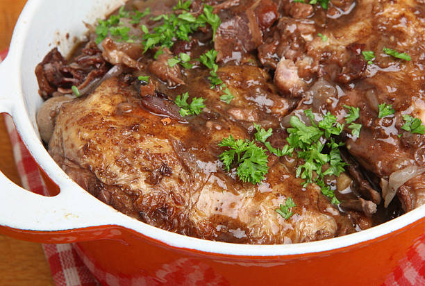 A close-up of a savory pot roast garnished with fresh parsley in a red Dutch oven.