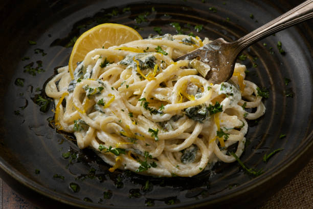 A plate of creamy pasta with lemon and herbs garnished with parsley.