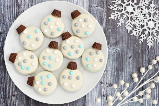 A plate of decorative snowman-themed cookies with blue, gray, and white accents.