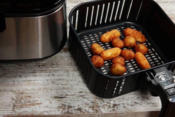 Fried food inside an air fryer basket on a wooden surface