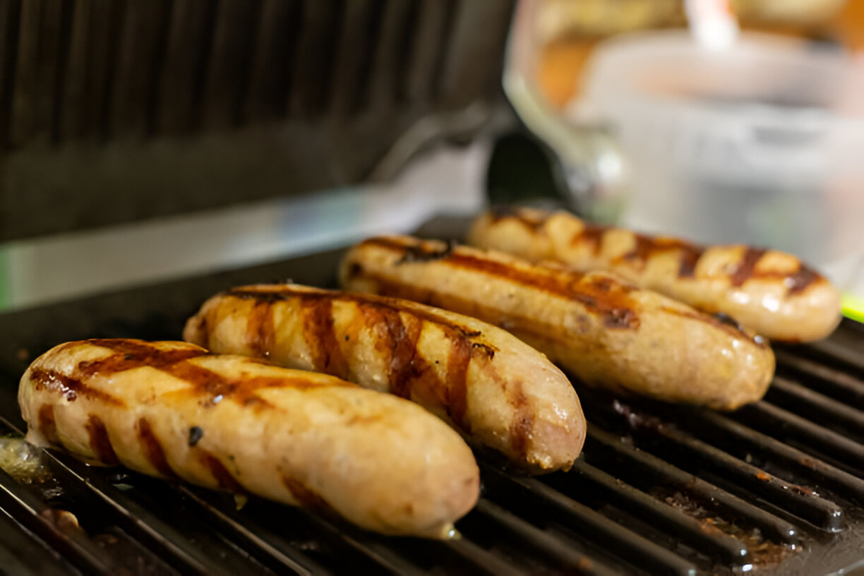 Grilled sausages on a barbecue grill with char marks