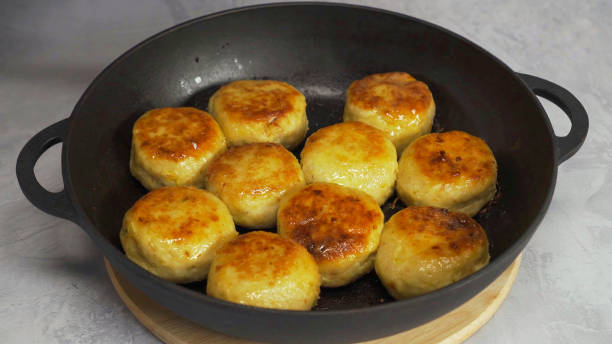 A cast iron skillet filled with golden-brown baked buns arranged in a circular pattern.