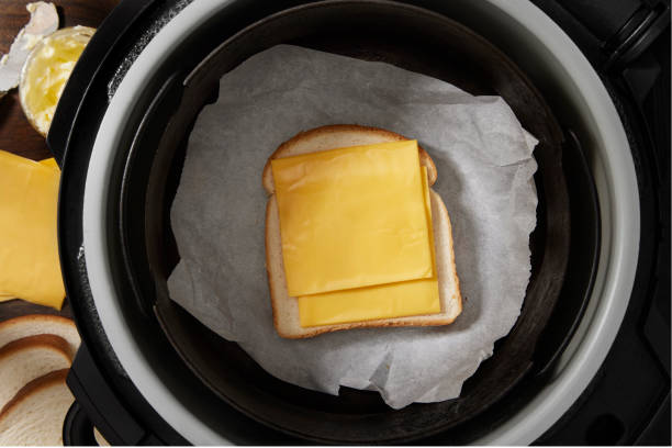 A slice of bread topped with two slices of cheese placed inside an air fryer.