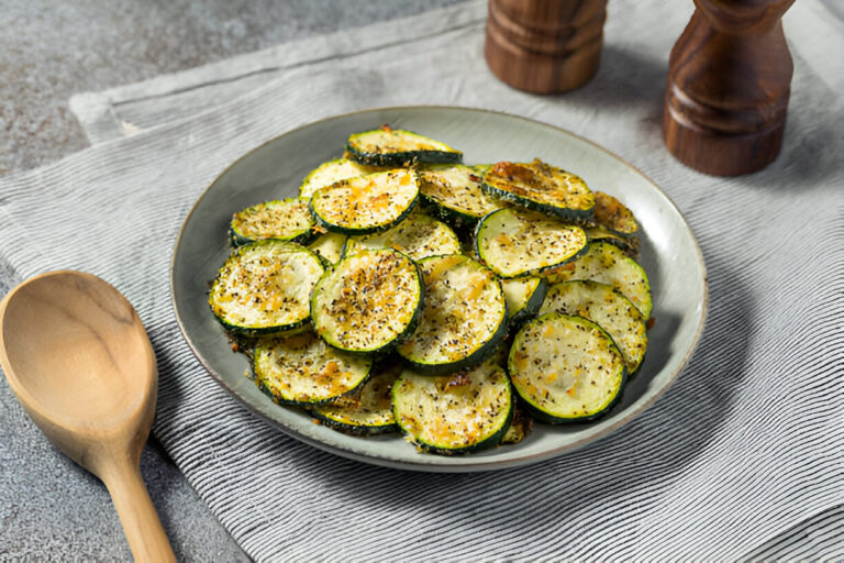 A plate of baked zucchini chips garnished with herbs