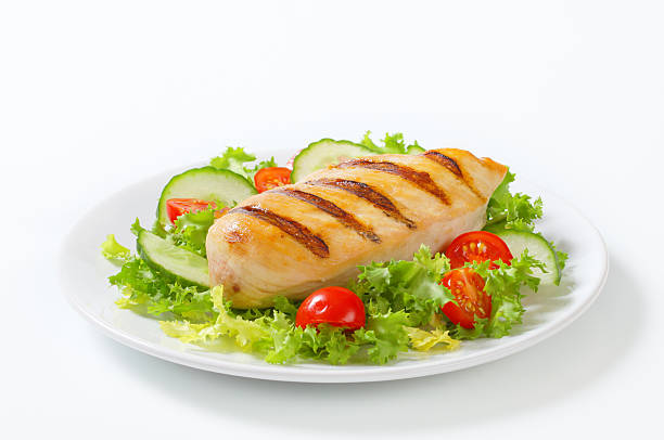 Grilled chicken breast served on a bed of fresh lettuce, cucumbers, and cherry tomatoes.