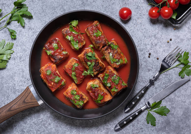 A skillet of cooked food garnished with herbs, set against a gray countertop.