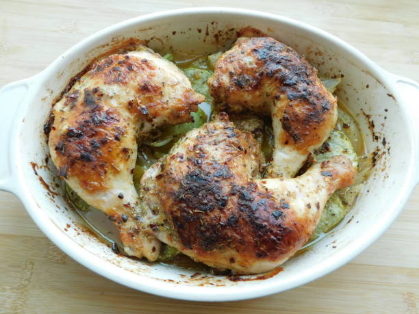 A whole cooked chicken with seasoning resting in a pot.