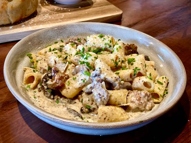 A creamy pasta dish with sausage, herbs, and cheese served in a bowl