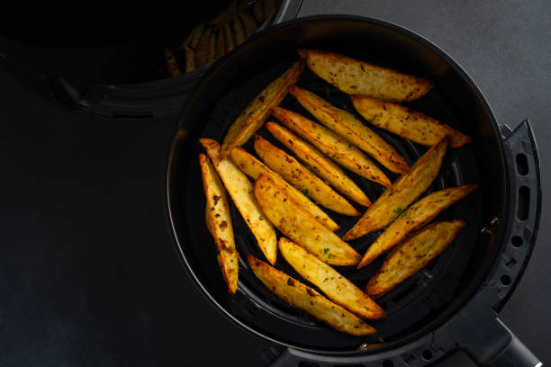 Crispy golden-brown potato wedges inside an air fryer basket.