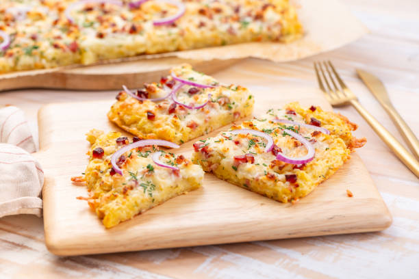 Three slices of delicious baked dish topped with onions and herbs on a wooden serving board.