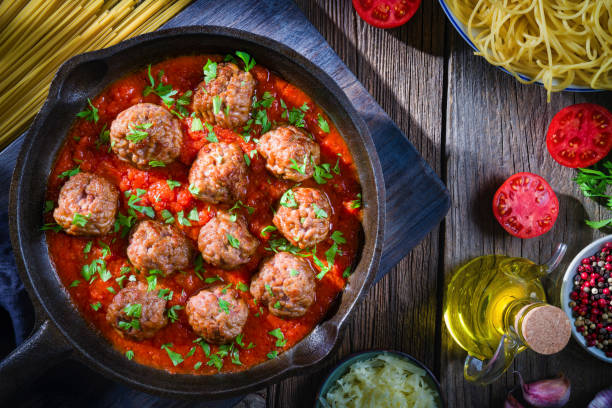 Delicious meatballs in a rich tomato sauce, garnished with fresh parsley, served in a cast-iron skillet.