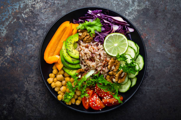 A colorful and healthy salad bowl featuring sliced vegetables, grains, and legumes.