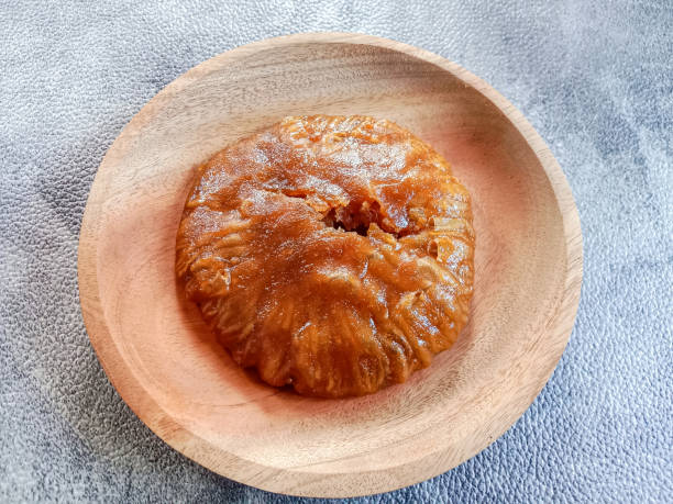 A round pastry sitting on a wooden plate.