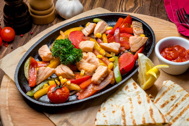 Sizzling chicken and vegetable platter served with tortillas and dipping sauce