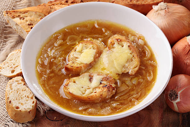 A bowl of French onion soup topped with melted cheese and served with bread.