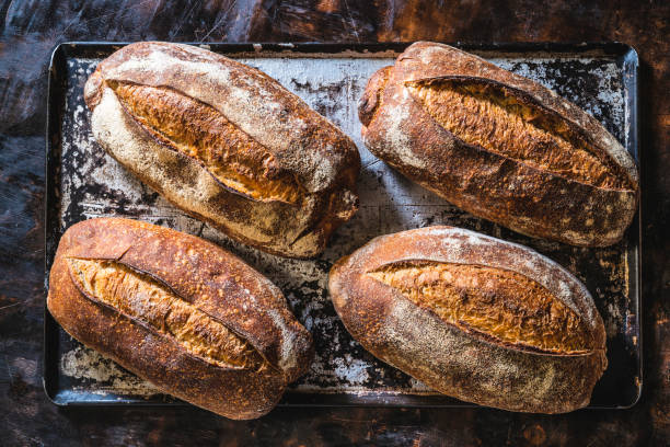 Fresh homemade bread on a wooden table with baking tools