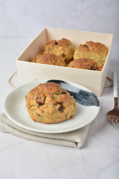 A plate of freshly baked biscuits next to a wooden box containing more biscuits.