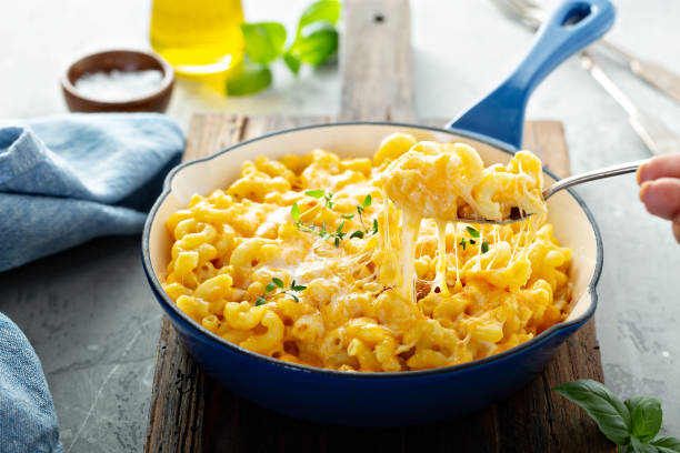 A serving of creamy macaroni and cheese in a blue dish garnished with fresh herbs.