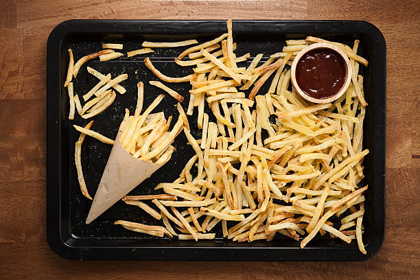 A tray filled with golden French fries and a small cup of ketchup.