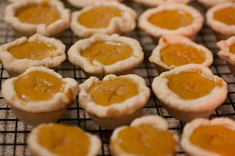 Mini pumpkin pies cooling on a wire rack.