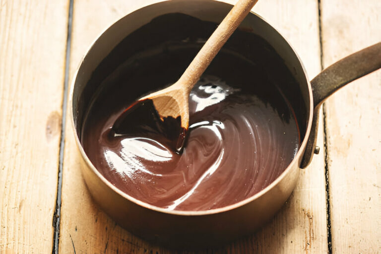 Melted chocolate in a copper saucepan with a wooden spoon