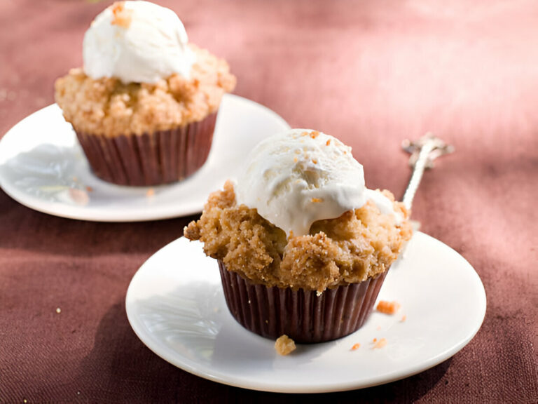 Two muffins topped with ice cream on white plates