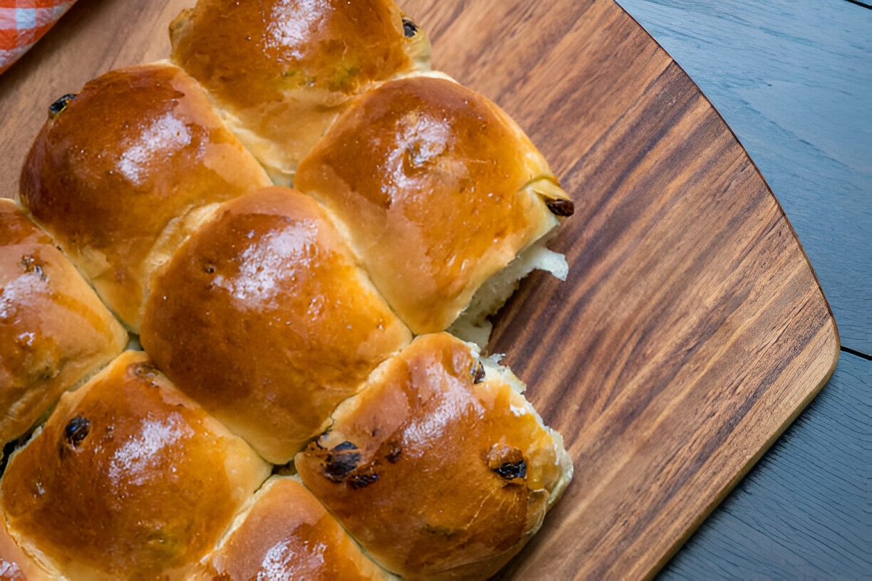 Freshly baked sweet bread rolls arranged on a wooden platter