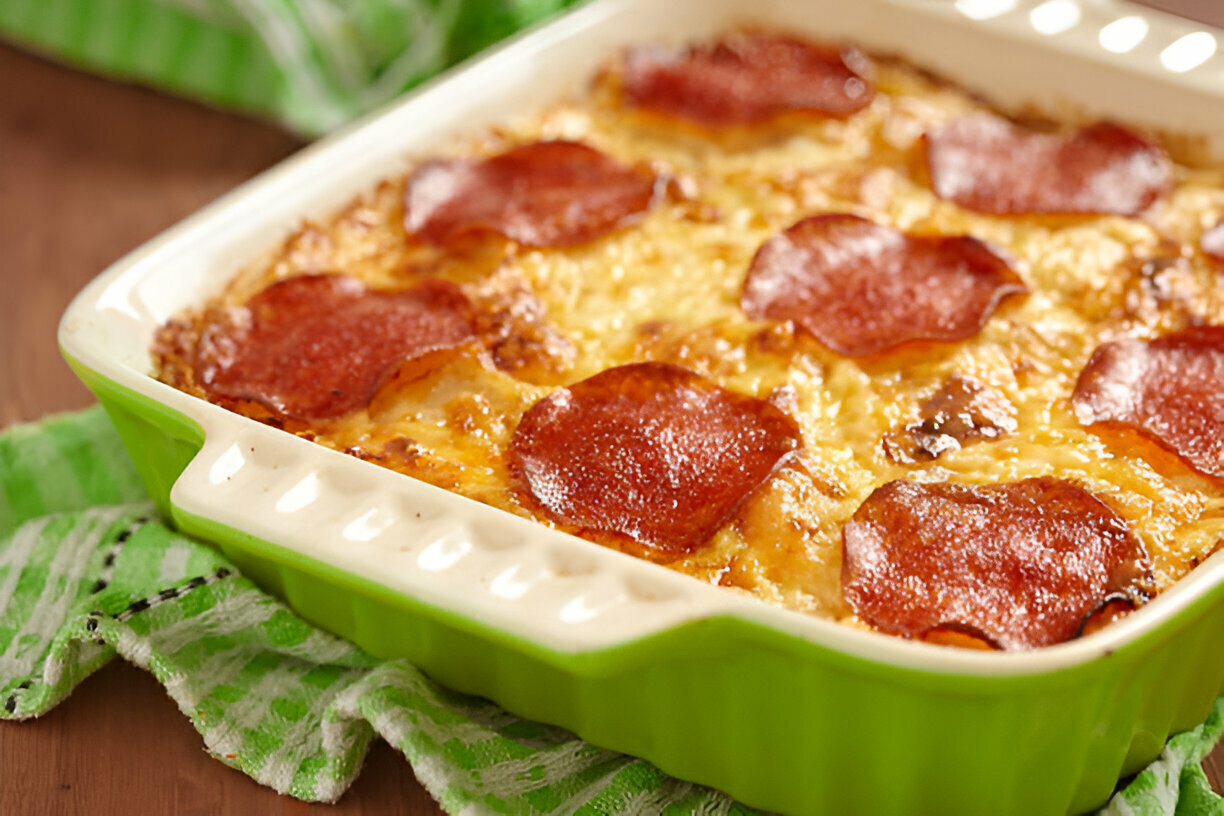 A delicious baked dish with melted cheese and pepperoni slices, served in a green ceramic dish.