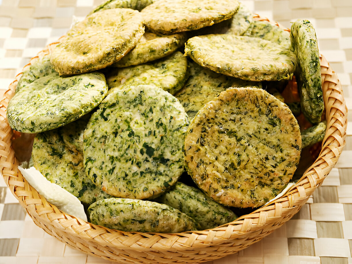 A basket filled with circular green snacks made from leafy greens.