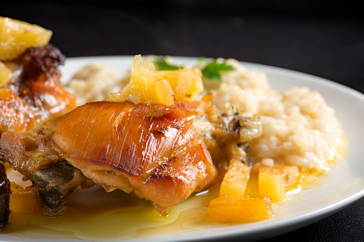 Close-up of a plate featuring glazed chicken with pineapple and rice.