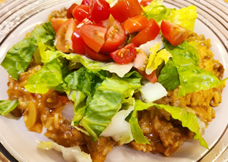 A plate of rice topped with lettuce and cherry tomatoes