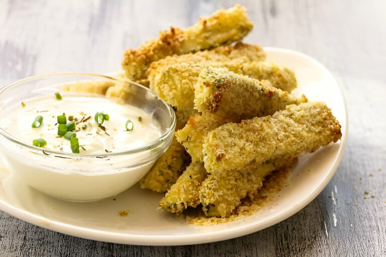 Crispy fried zucchini sticks served with a creamy dipping sauce and sprinkled with green onions.